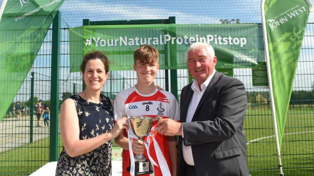 Conall Heron of O'Donovan Rossa GAC is presented with the Boys Division 1 Cup by Anne-Claire Monde, Marketing Manager of John West, and Brendan O'Brien, Chairman of the National Féile Committee. 