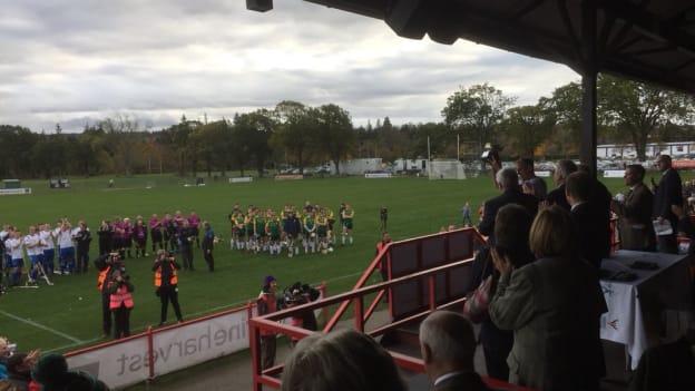 Players from both teams look on as Scottish captain Grant Irvine lifts the Marine Harvest Quaich after Scotland's victory over Ireland in the Senior Hurling-Shinty International at Bught Park Inverness. 