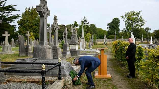 Uachtarán Chumann Lúthchleas Gael, Labhrás Mac Cárthaigh, agus bláthfhleasc á leagan aige ag uaigh Mhichil Cíosóg i gcomhluadar an Mhoinsíneora, Eoin Thynne, i Reilig Ghlas Naíon inniu