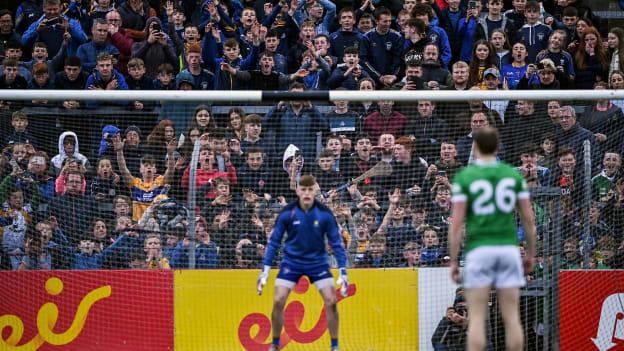 Clare supporters look on as Robbie Bourke, Limerick, prepares to take a penalty against Clare goalkeeper Tristan O'Callaghan at Cusack Park.