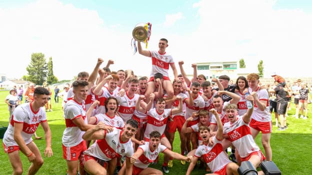 Derry captain Matthew Downey holds the Tom Markham Cup, surrounded by his Derry teammates. 