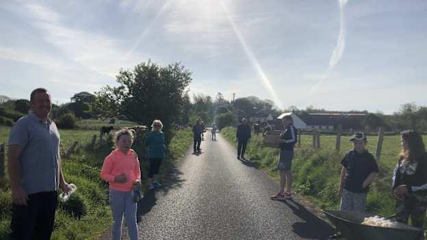 Shamrock Gaels club chairperson, Lauri Quinn, and fellow members of the local community cleaning the route after the club's Darkness into Light 24-hour relay run for Pieta House. 