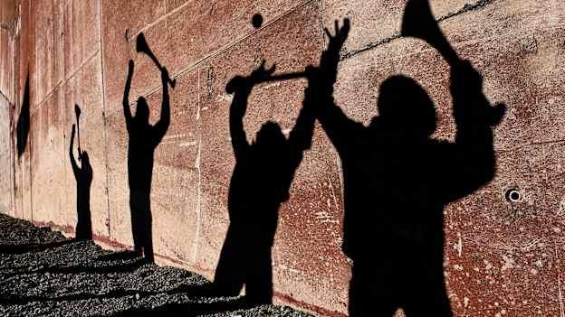 The shadows of local children from Galway, Robert Noone, brothers, Conor and Cian Geoghegan and Danny Morrissey, as they practice their hurling skills