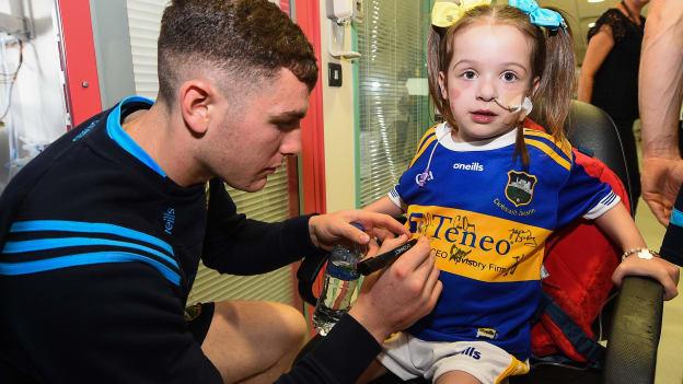Holly Carroll, aged 4, from Clonmel, Co. Tipperary, has her jersey signed by Paddy Cadell of Tipperary on a visit by the Tipperary All-Ireland Senior Hurling champions to Children's Health Ireland at Crumlin in Dublin. 