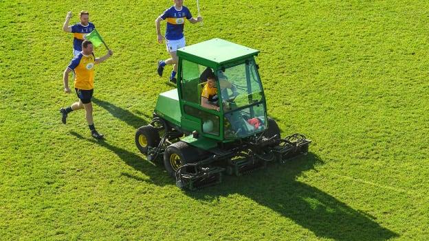 Kilkenny goalkeeper Eoin Murphy driving a tractor being followed by former Tipperary stars Brendan Cummins, Paddy Stapleton, and Lar Corbett.
