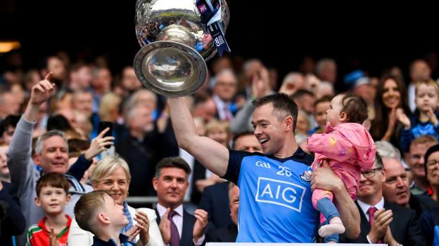 Dean Rock lifts the Sam Maguire Cup, while also holding his daughter Sadie, following the 2023 All-Ireland SFC Final at Croke Park. Photo by Seb Daly/Sportsfile