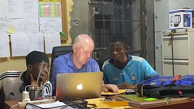 Pádraig Ó Fainín helping two of his Sables Shamrocks players with their visa applications for the 2026 GAA World Games. 