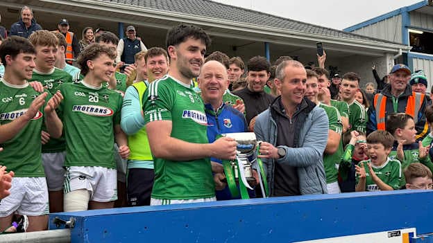 Matthew Carey receives the Connolly Cup from Longford GAA Chairperson, Derek Fahy, and competition sponsor David Hanley of Peter Hanley Motors.