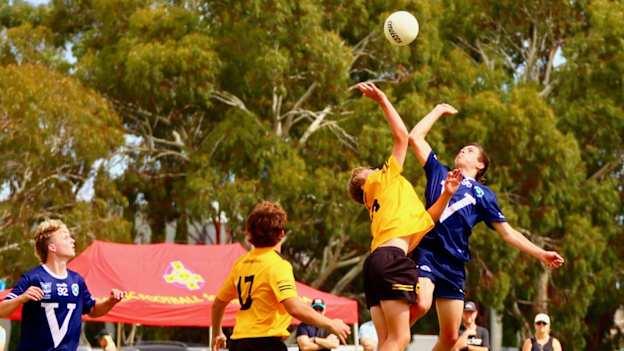 Western Australia (yellow) and Victoria under-14 boys compete for a ball at the Australasia Féile in Adelaide, March 2023.