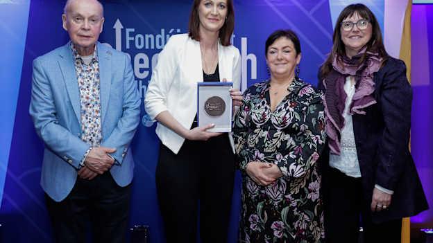 Áine Uí Choinn in éineacht le Pat Carey, Cathaoirleach Ghlór na nGael, agus Aedín na Bhriain, Oifigeach Forbartha Gaeilge CLG na Mumhan, ag Bronnadh Gradam Fhondúireacht Sheosaimh Mhic Dhonncha 2025
