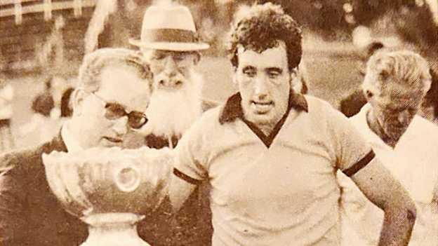 Ambassador of Ireland to Australia, Joseph Small, presenting New South Wales football captain, Arty Lundy, with the Pat J O'Loughlin trophy at the 1982 championships in Brisbane. Behind are NSW GAA great Kerry Murphy, and GAA Australasia secretary, Jim Farnan. Source: Kerry Murphy's Memoirs: The Diaries of an Irish Immigrant.