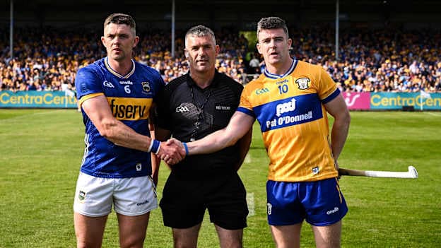 Referee James Owens stands between the two captains, Ronan Maher of Tipperary and Tony Kelly of Clare, before the 2025 Munster GAA Hurling Senior Championship Round 3 match between Clare and Tipperary at Zimmer Biomet Páirc Chíosóg in Ennis, Clare. Photo by Ray McManus/Sportsfile