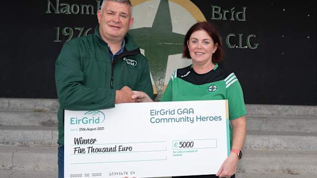 Conal McLoone of EirGrid presents Mary Cooke of Naomh Bríd GAA with a cheque for €5,000 after she was named the 2025 EirGrid Community Hero winner.