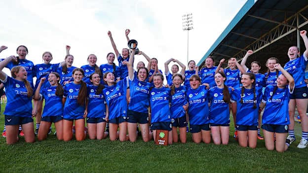 Erin's Own players celebrate with the trophy after the cup final match between Erin's Own and Barryroe during the 2026 John West Féile na nGael Camogie and Hurling National Finals at Laois Hire O’Moore Park & LOTB Centre Of Excellence in Portlaoise, Laois. Photo by Thomas Flinkow/Sportsfile.
