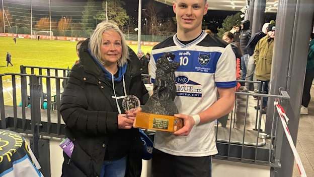 Lorraine O'Kane presents the Man of the Match award, named after her late husband James, to St. Patrick's, Maghera captain, Rian Collins, after the Mageean Cup Final. 
