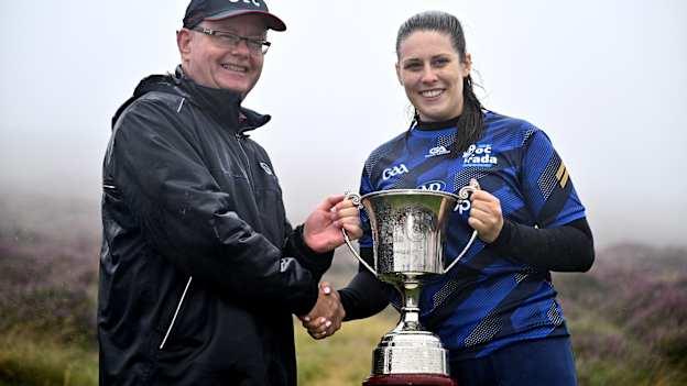 Molly Lynch of Cork is presented the winning trophy for the Senior Camogie by Camogie Association president Brian Molloy after the 2024 M. Donnelly GAA All-Ireland Poc Fada Finals at Annaverna Mountain in the Cooley Peninsula, Ravensdale, Louth. Photo by Ben McShane/Sportsfile.
