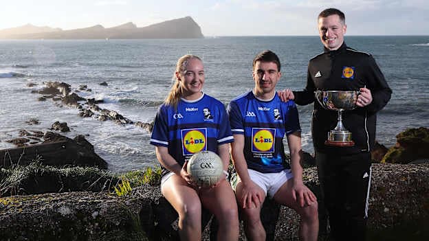 Kerry LGFA star, Caoimhe Evans, Kerry footballer, Brian Ó Beaglaoich, and Comórtas Chairperson, Pádraig Óg Ó Sé, pictured at the launch of the Lidl Comórtas Peile Páidí Ó Sé 2026 while taking in the views at Dooneen Pier, overlooking Smerwick Harbour and The Three Sisters on the Dingle Peninsula.