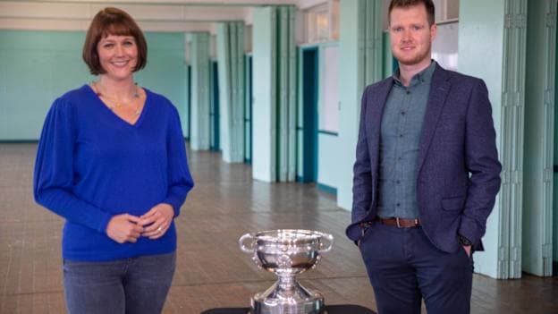 Broadcasters Gráinne McElwain and Damien Ó Dónaill pictured with the Rann na Feirste trophy.