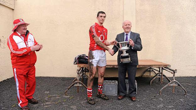 Jonty O'Leary looks on as Cork captain Ray Carey is presented with the 2012 McGrath Cup. 