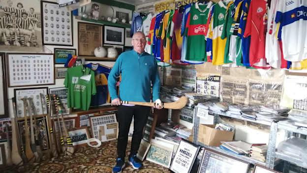 Jim Whelan stands in his memorabilia museum, holding the hurl used by Martin Treacy of Kilkenny in the 1963 All-Ireland final. 