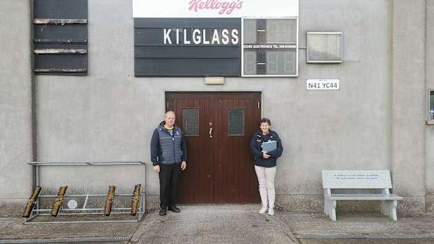 Aidan Tully and Noreen Corcoran stand underneath the scoreboard at Kilglass Gaels GAA club.