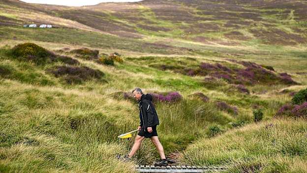 A steward crosses a small bridge during the M. Donnelly All-Ireland Poc Fada finals at Annaverna Mountain. Photo by Shauna Clinton/Sportsfile