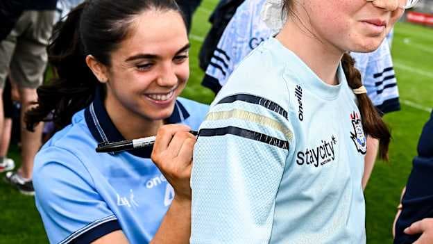 Niamh Crowley of Dublin sign a young supporter's jersey after the 2025 TG4 All-Ireland Ladies Football Senior Championship quarter-final match between Dublin and Cork at Parnell Park in Dublin. Photo by Seb Daly/Sportsfile.