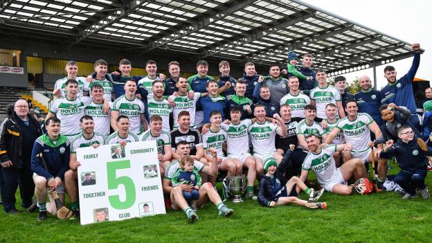 After victory over James Stephens in the 2022 County SHC Final, Ballyhale Shamrocks players pose with a poster that includes the pictures of five valued club-members who died during the five years they've won five Kilkenny SHC titles in a row. 