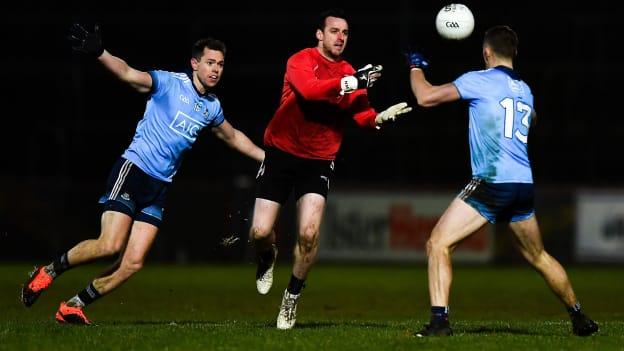 Tyrone's Niall Morgan offloads possession as Dublin's Dean Rock and Paiul Mannion close in.