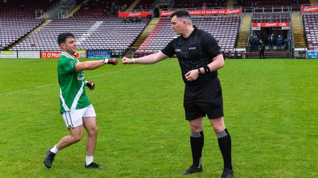 Maigh Cuilinn captain Dessie Conneely pictured with referee Anthony Coyne.