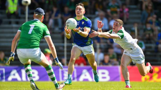 Paudie Clifford of Kerry handpasses a point under pressure from Paul Maher and Limerick goalkeeper Donal O'Sullivan during the Munster GAA Football Senior Championship Final match between Kerry and Limerick at Fitzgerald Stadium in Killarney.