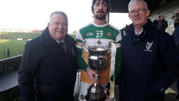 Offaly's Ben Conneely being presented with the Kehoe Cup by Leinster GAA's Jim Bolger and Pat Teehan.
