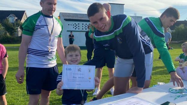 Gearoid Hegarty pictured presenting medals and certificates to juvenile members of his club, St. Patrick's, recently. 