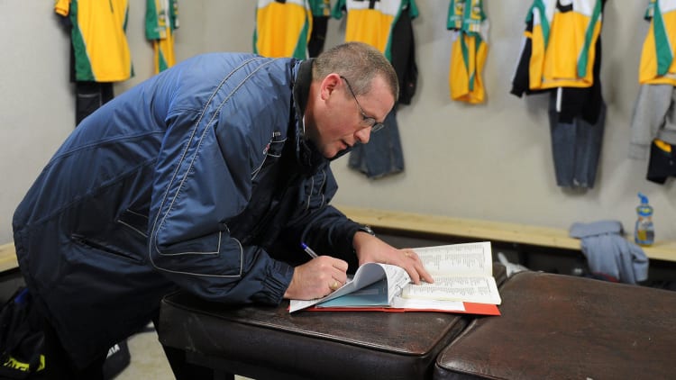 A Club Secretary signing a team sheet