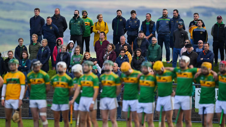 Dunloy supporters stand behind their team for Amhrán na bhFiann prior to the Antrim County Senior Hurling Championship Final match between Dunloy Cuchullains and Loughgiel Shamrocks at Páirc Mhic Uilín in Ballycastle, Antrim.