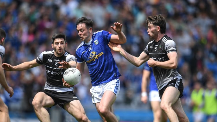 Gerard Smith, Cavan in Tailteann Cup action against Sligo's Nathan Mullen and Luke Towey.