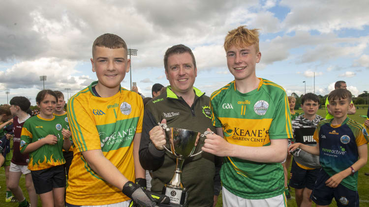 Cathaoirleach John West Féile,Diarmuid Ó Cathail, presents Claregalway captains Jamie King and Sean O’Callaghan with the Division 1 Cup after Claregalway defeated Austin Stacks (Kerry) in the final at the John West Féile Peile na nÓg National Gaelic and Ladies football finals 2022 at the GAA National Games Development Centre Campus, Abbotstown, Dublin, Eighty-eight club sides from Ireland, the UK, Europe and US competed in the final stages of the under-15 competition across nine venues, one of the biggest underage sporting events on the continent, sponsored for the seventh time by John West.