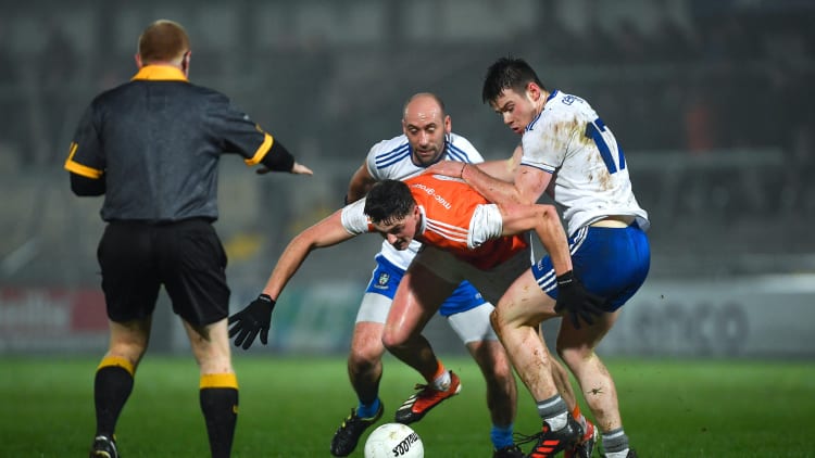 Connaire Mackin of Armagh in action against Gavin Doogan and Barry Kerr, right, of Monaghan, as referee Barry Cassidy looks on, during the Bank of Ireland Dr McKenna Cup Round 3 match between Armagh and Monaghan at the Athletic Grounds in Armagh.