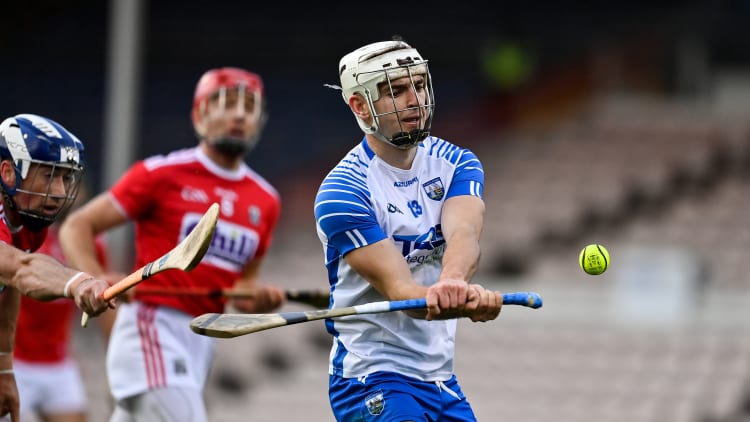 Dessie Hutchinson of Waterford scores a point despite the best efforts of Seán O'Donoghue of Cork during the Munster GAA Hurling Senior Championship Semi-Final match between Cork and Waterford at Semple Stadium in Thurles, Tipperary.