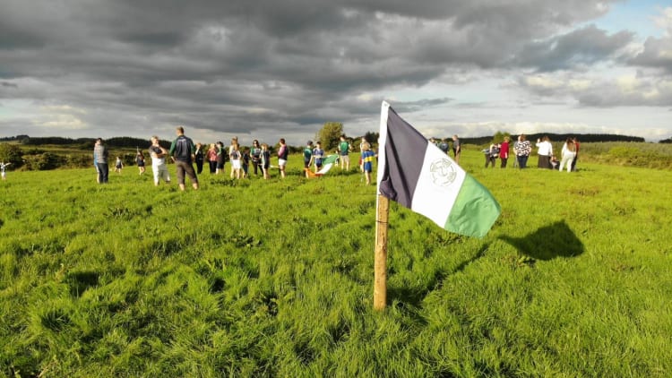 Laochra Óg volunteers plant a club flag on the 8.3 acre site where they'll develop their new home.