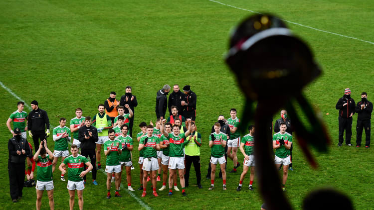 Mayo players look on as captain Aidan O'Shea lifts the cup following the 2020 Connacht GAA Football Senior Championship Final match between Galway and Mayo at Pearse Stadium in Galway.