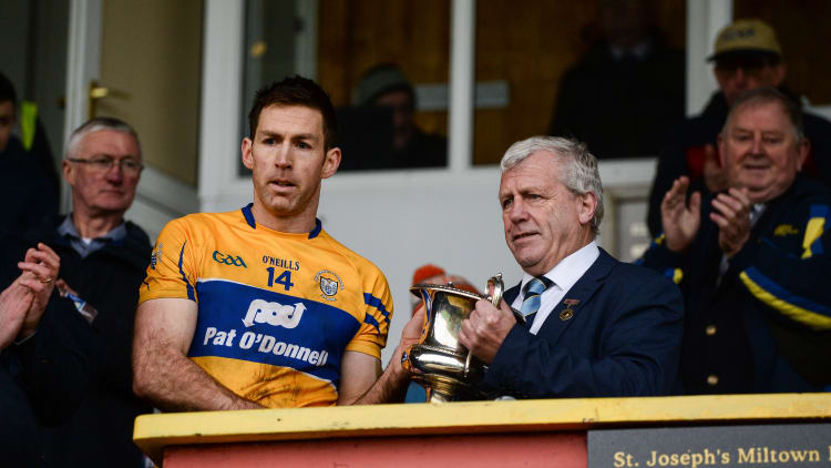 Clare captain Gary Brennan is presented with the McGrath cup by Munster Council Chairman Jerry O'Sullivan after the McGrath Cup Final match between Cork and Clare at Hennessy Park in Miltown Malbay, Co. Clare.